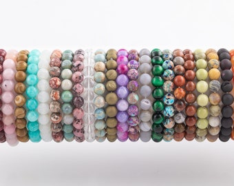 May include: A collection of 20 colorful beaded bracelets, each with a different pattern and color. The bracelets are made of natural stones and are stacked on top of each other.