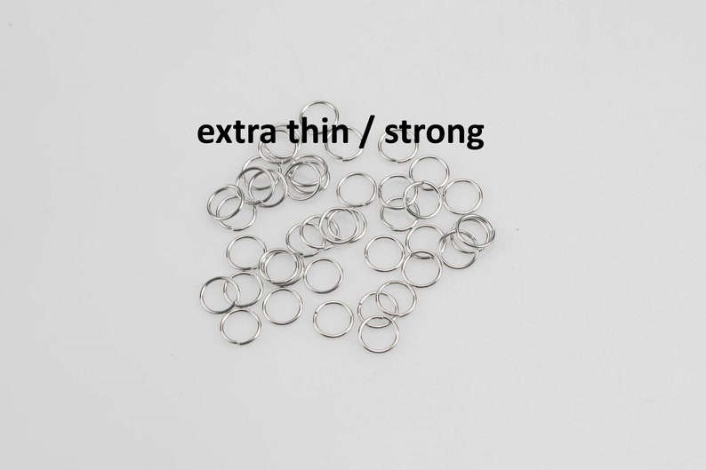 May include: A pile of silver jump rings, labeled "extra thin / strong". These rings are small and delicate, perfect for jewelry making.