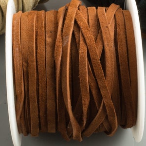 May include: A spool of brown leather cord, wound tightly and ready for crafting projects.