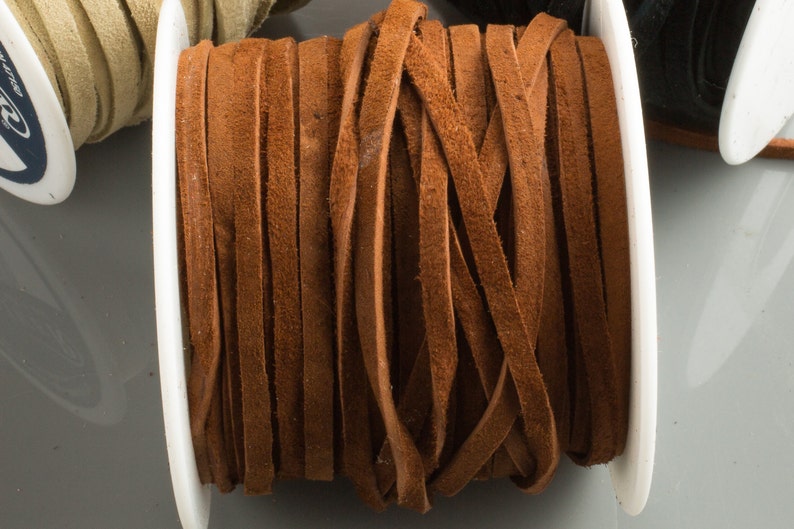 May include: A spool of brown leather cord, wound tightly and ready for crafting projects.