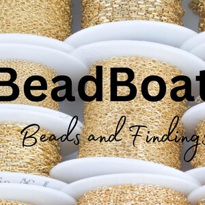 May include: Close-up of spools of gold chain, arranged in a stack. The spools are labeled "BeadBoat1 Beads and Findings".