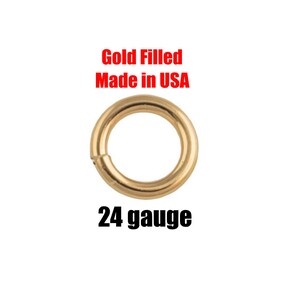 May include: A gold-filled, 24-gauge jump ring. The text "Gold Filled Made in USA" is in red above the ring. The jump ring is a circular shape with a small opening for attaching to other jewelry components.