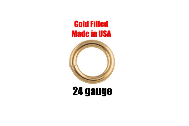 May include: A gold-filled, 24-gauge jump ring. The text "Gold Filled Made in USA" is in red above the ring. The jump ring is a circular shape with a small opening for attaching to other jewelry components.