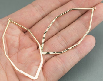 Puede incluir: Dos aros de pendientes de metal dorado con un diseño geométrico facetado. Los aros están abiertos y listos para ser utilizados en la elaboración de joyas.