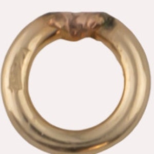 May include: A gold-toned metal ring with a smooth, rounded surface.