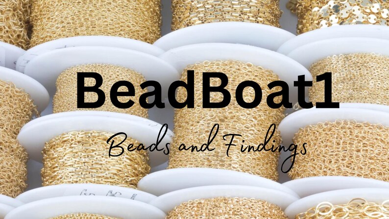 May include: Close-up of spools of gold chain, arranged in a stack. The spools are labeled "BeadBoat1 Beads and Findings".