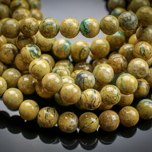 Peut inclure: Un brin de perles de jaspe jaune et vert. Les perles sont rondes et ont un aspect marbr&eacute;.