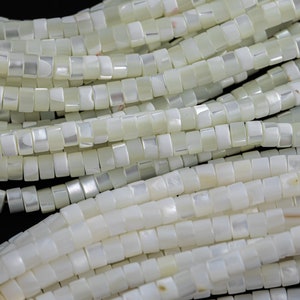 Puede incluir: Una hebra de cuentas cuadradas de concha blanca. Las cuentas tienen un ligero brillo iridiscente.