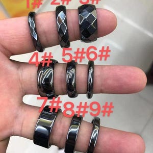 May include: Nine black hematite rings with different styles and finishes. The rings are numbered 1 through 9.