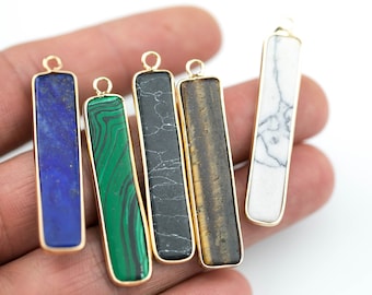 May include: Five gold-rimmed bar pendants with different natural stone inlays. The stones are lapis lazuli, malachite, black onyx, tiger's eye, and white howlite.