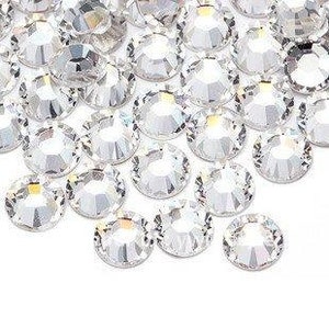 May include: A pile of clear crystal rhinestones, also known as glass gems, for crafting and jewellery making.
