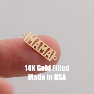 Puede incluir: Encanto de oro relleno con la palabra "MAMA" recortada. 14K Gold Filled Made in USA.
