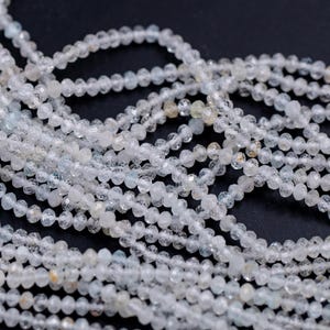 May include: Strands of small, faceted, pale blue-green gemstone beads. The beads are strung together, creating a delicate and shimmering effect. The beads are a light, translucent color, and the overall aesthetic is elegant and refined.