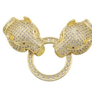 May include: Gold-tone chain clasp with two animal head ends, each with a red stone eye and covered in clear rhinestones.