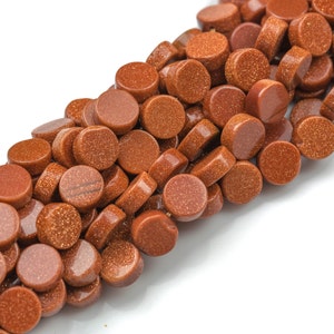 May include: A strand of round, brown sandstone beads. The beads have a rough, textured surface and a natural, earthy color.