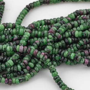 May include: A strand of green and pink gemstone beads. The beads are round and have a smooth, polished finish.