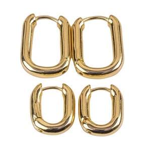 May include: A set of four gold-toned hoop earrings. The earrings are oval shaped and have a smooth finish.
