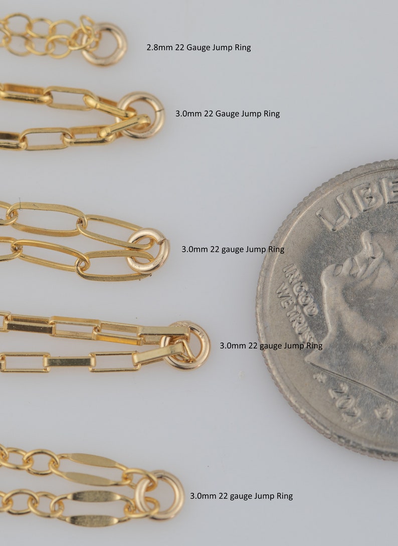 May include: Five gold jump rings of different sizes next to a US quarter. The jump rings are 2.8mm and 3.0mm in diameter. The text on the image reads "2.8mm 22 Gauge Jump Ring", "3.0mm 22 Gauge Jump Ring", "3.0mm 22 gauge Jump Ring", "3.0mm 22 gauge Jump Ring", and "3.0mm 22 gauge Jump Ring".