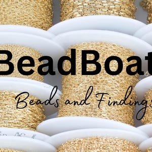 K&ouml;nnte beinhalten: Nahaufnahme von Spulen mit goldener Kette, die in einem Stapel angeordnet sind. Die Spulen sind mit "BeadBoat1 Beads and Findings" beschriftet.