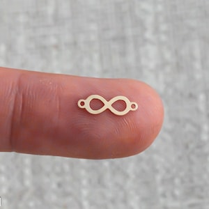 May include: Gold infinity symbol charm with two jump rings for attaching to jewelry or crafts.