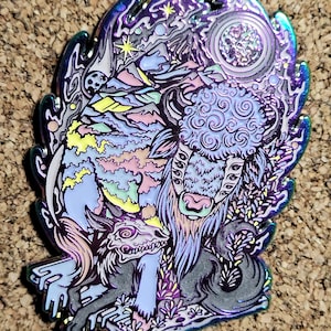 May include: A colorful enamel pin featuring a stylized bison with a swirling pattern, a wolf-like creature with a skull-like head, and a background of mountains, stars, and a crescent moon.