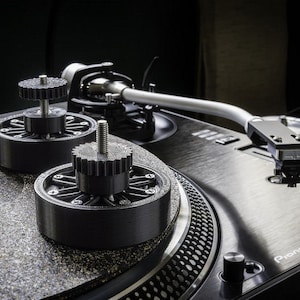 May include: A black turntable with a silver tonearm and a black mat. There are two black 3D printed record stabilizers on the mat. The turntable has a Pioneer logo on the front.