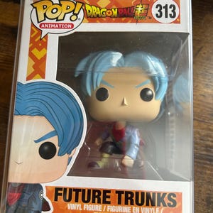 Puede incluir: Figura de vinilo Funko Pop! de Future Trunks de Dragon Ball Super. La figura tiene cabello azul y viste un atuendo rojo y azul. El embalaje incluye el logo Pop! Animation y el número 313.