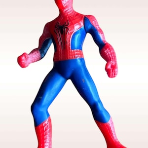 May include: A red and blue plastic action figure of Spider-Man in a fighting pose. The figure has a detailed design with a spider logo on the chest.