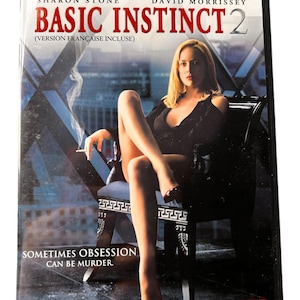 May include: DVD cover for the movie Basic Instinct 2, featuring Sharon Stone in a black dress and red heels, sitting on a chair. The text on the cover reads "Basic Instinct 2" and "Sometimes obsession can be murder."