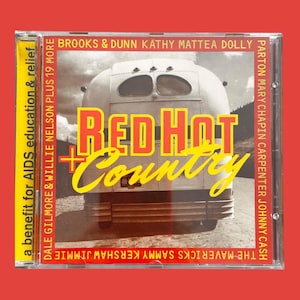 Puede incluir: Una portada de CD roja y amarilla con el texto "Red Hot Country" y una foto de un autobús vintage. El CD es un beneficio para la educación y el alivio del SIDA y presenta artistas como Dolly Parton, Mary Chapin Carpenter, Johnny Cash, The Mavericks, Sammy Kershaw, Jimmie Dale Gilmore, Willie Nelson, Brooks & Dunn y Kathy Mattea.