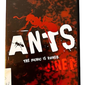 May include: DVD case for the movie "Ants" featuring Suzanne Somers and Robert Foxworth. The cover has a red and black background with a large red ant graphic and the word "ANTS" in white. The text "THE PICNIC IS RUINED" is also visible.
