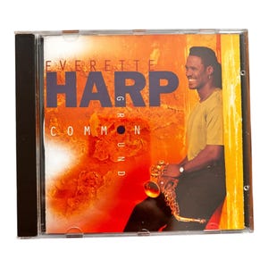 May include: A CD case with a red, orange, and yellow background. The album cover features a man playing a saxophone. The album title is "Everette Harp Common Ground".