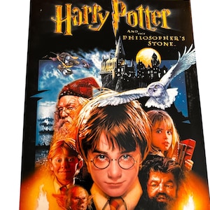 May include: DVD of "Harry Potter and the Philosopher's Stone" with a dark background and images of characters from the film. The title is in gold lettering, and the cover features Harry Potter, an owl, and other characters.