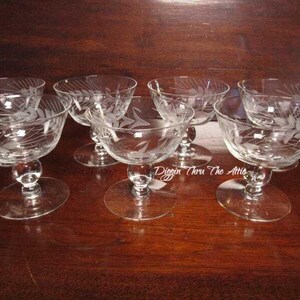 May include: Set of six clear glass stemmed dessert cups with an etched wheat design.