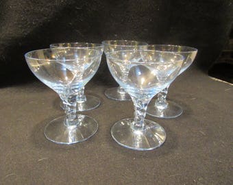 Puede incluir: Juego de cuatro vasos de cristal transparente con tallo y tallo retorcido.