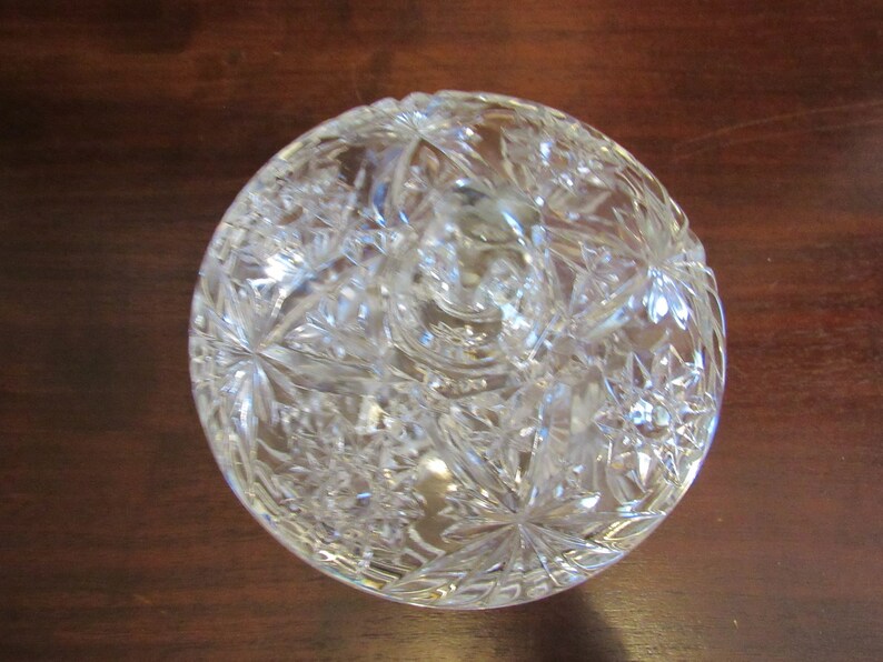 May include: A clear glass bowl with a cut glass design. The bowl is round and has a raised center.