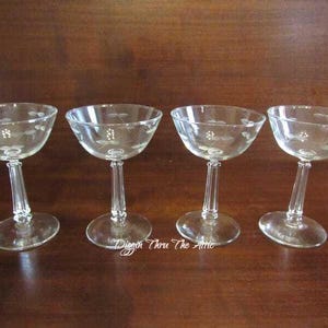 Puede incluir: Juego de cuatro copas de champán de cristal transparente con un delicado diseño floral grabado. Las copas tienen una forma clásica con una copa ancha y un tallo largo.