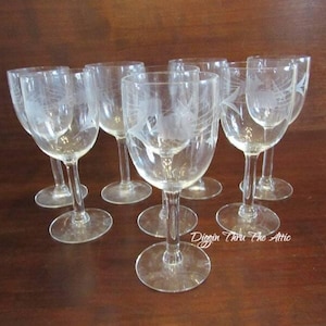 May include: Set of eight clear glass wine glasses with etched designs. The glasses have a delicate, elegant look.