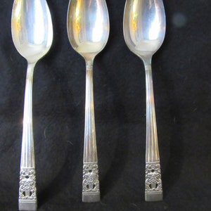 Puede incluir: Tres cucharas de plata con diseños florales ornamentados en los mangos. Las cucharas están pulidas y brillantes.