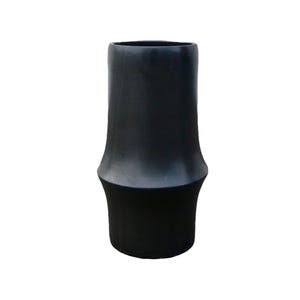 May include: A tall, black ceramic vase with a unique shape. The vase has a wide base that tapers inward, then flares out again towards the top. The top opening is wide. The vase is a solid black color and has a smooth finish.