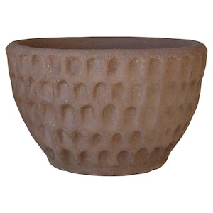 May include: A terracotta planter with a textured, dimpled surface. The planter is round and has a wide, shallow opening.
