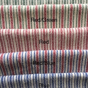 May include: Five fabric swatches with different colored stripes. The top swatch is green stripes, the second is red and green stripes, the third is red stripes, the fourth is red and blue stripes, and the bottom swatch is blue stripes.