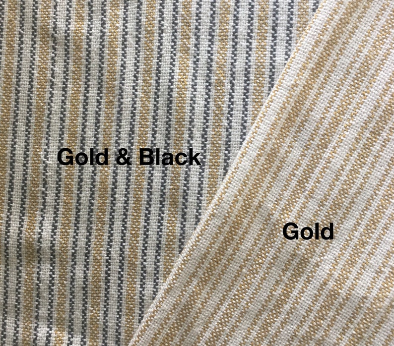 May include: Close-up of two fabric swatches. The left swatch is a striped pattern with gold and black stripes. The right swatch is a striped pattern with gold stripes. The text "Gold & Black" is written on the left swatch and "Gold" is written on the right swatch.