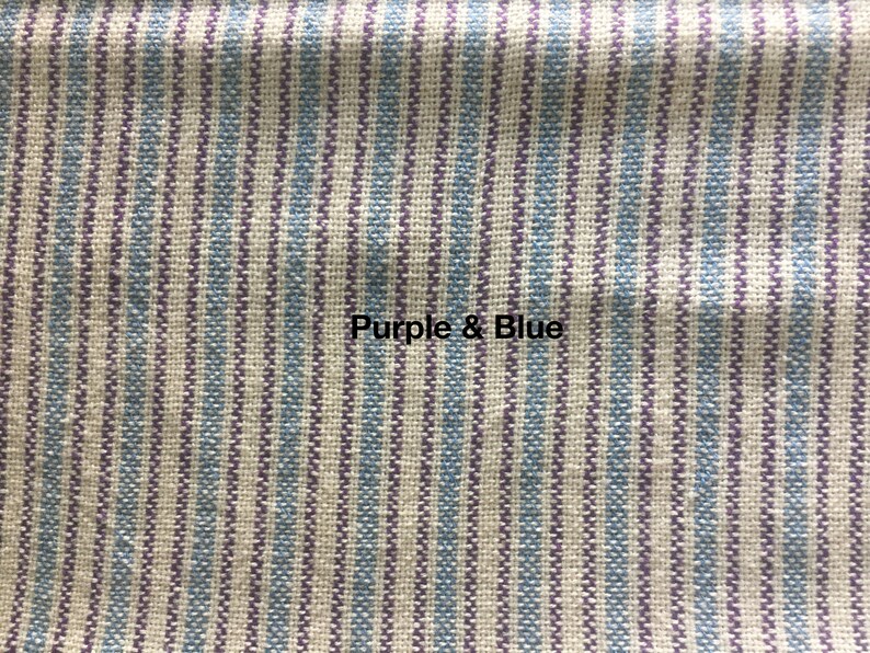 May include: Close-up of a fabric with vertical stripes in shades of purple and blue. The fabric has a woven texture.