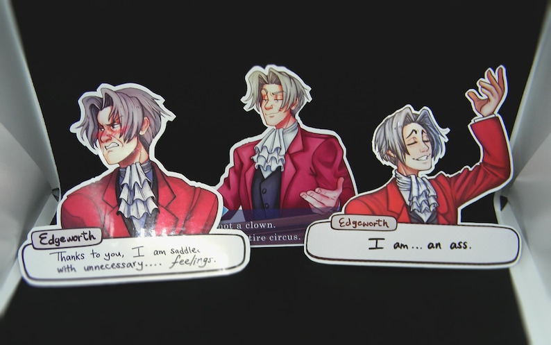 May include: Three stickers featuring a cartoon character with white hair and a red suit. The stickers have text bubbles with the following text: "Thanks to you, I am saddle with unnecessary... feelings." "I am... an ass." "Not a clown. Entire circus."