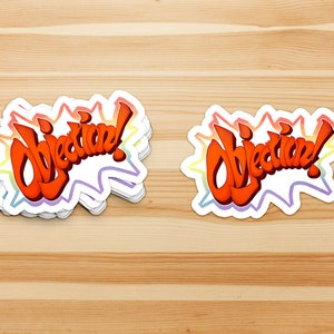 May include: A stack of "Objection!" stickers with a rainbow border. The stickers are white with red, orange, yellow, green, blue, indigo, and violet colors in the border.