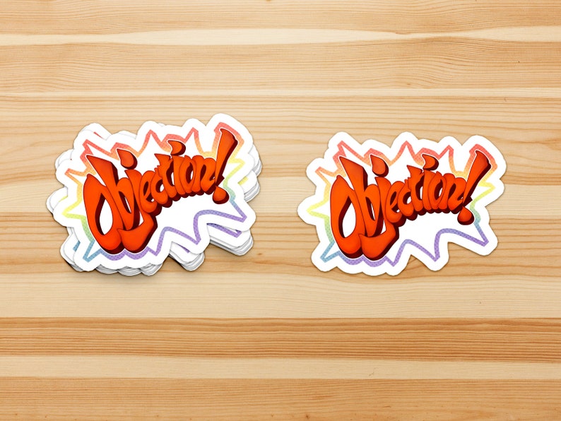 May include: A stack of "Objection!" stickers with a rainbow border. The stickers are white with red, orange, yellow, green, blue, indigo, and violet colors in the border.