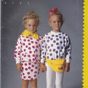 May include: Two girls wearing polka dot shirts and skirts. The girl on the left is wearing a white shirt with pink polka dots and a yellow scarf. The girl on the right is wearing a white shirt with purple polka dots and a yellow fanny pack. Both girls are wearing white leggings and white sneakers with colorful accents.