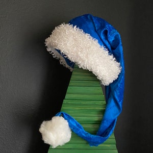Blue crushed velvet with white furry fleece trim and 3 inch pom pom