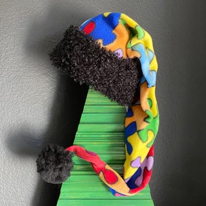 Autism Awareness all-over puzzle print fleece with black furry fleece trim and 3 inch pom pom
